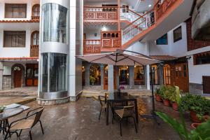a patio with a table and chairs and an umbrella at Quechua Hotel Cusco in Cusco