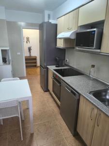 a kitchen with a black refrigerator and a table at BRISAS DEL MAR Eddy,,AIR,WIFI in Candelaria