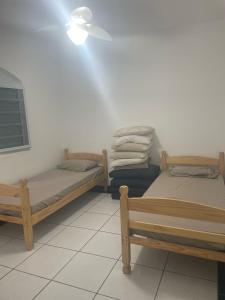 2 camas en una habitación con ventilador de techo en Apto com 1 dormitorio proximo a praia, en Praia Grande