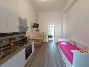 a kitchen with a pink couch in a room at La casa di Simo in Lodi