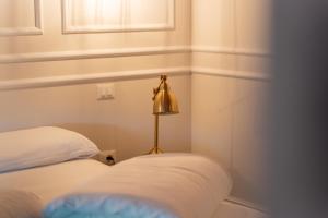 a room with a bed and a lamp next to it at Locanda Gaudemus Boutique Hotel in Sistiana