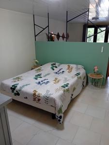 ein Bett in einem Zimmer mit einer Decke darauf in der Unterkunft Location 4 personnes avec jardin in Carsac-Aillac