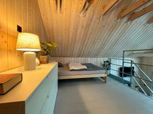 a room with a bed and a lamp on a desk at domek w stylu stodoły in Narty