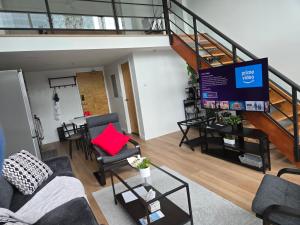 a living room with a couch and chairs and a staircase at New York Style Loft in Downtown Vancouver in Vancouver