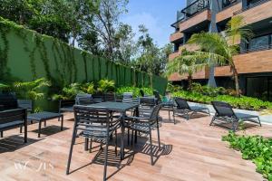 a group of tables and chairs on a patio at Modern 1 Bedroom Apartment with Luxury Amenities at Paramar Black by Waves in Tulum