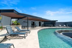 a patio with chairs and a swimming pool at Modern 1 Bedroom Apartment with Luxury Amenities at Paramar Black by Waves in Tulum +20 photos