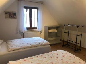 キツェック・イム・ザウザルにあるFerienhaus Neuholdのベッド2台と窓が備わる屋根裏部屋です。