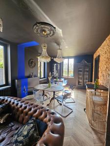 a living room with a couch and a table at La Villa du Clos Normand Les Petites Dalles - Maison d'hôtes in Saint-Martin-aux-Buneaux