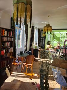 a room with a table and chairs and a book shelf at La Villa du Clos Normand Les Petites Dalles - Maison d'hôtes in Saint-Martin-aux-Buneaux