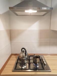 a stove with two tea pots on top of it at Tkhibuli guest house in Tqibuli +8 photos