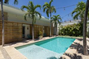 una piscina davanti a una casa con palme di BOHO Tamarindo a Tamarindo
