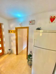 a kitchen with a white refrigerator in a room at Casa La Alegria in Maçanet de la Selva