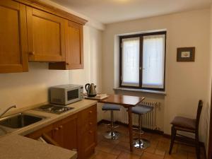 a small kitchen with a table and a microwave at Da Petro Appartamenti per vacanze in Pila