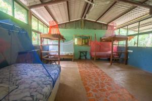 - une chambre avec un lit et une table dans l'établissement Hostal and camping Huellitas Ometepe, à Santa Cruz