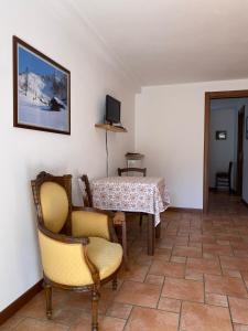 a room with a table and chairs and a television at Da Petro Appartamenti per vacanze in Pila