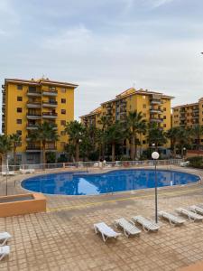 a swimming pool with lounge chairs and buildings at BRISAS DEL MAR Eddy,,AIR,WIFI in Candelaria