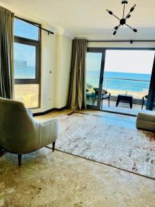 a living room with a couch and a view of the ocean at ALEX HOMES - Gleem Luxury Apartments with Direct Sea View in Alexandria