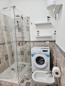 a bathroom with a washing machine and a sink at Una finestra sul mare in Isola delle Femmine +24 photos