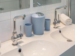 a bathroom with two sinks and two faucets at Holiday Home in Zoutelande near Sunny Beach in Zoutelande +32 photos