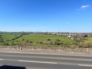 a view of a field and a road with a fence at Valley View in Keynsham