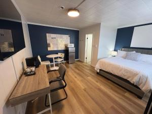 a bedroom with a bed and a desk and a table at Remo Stays in Unity
