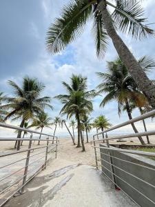 una playa con palmeras y una valla en Pie en la arena Playa de Ocean IV, en Samaritá