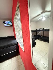 sala de estar con pared roja y espejo en Pie en la arena Playa de Ocean IV, en Samaritá