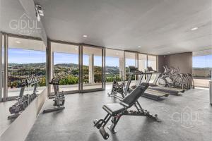 un gimnasio con cintas de correr y máquinas de ejercicio cardiovascular en un edificio en Cozy, Modern and Centric Apartment with pool and gym, en San Salvador