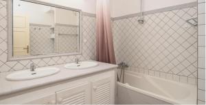 a bathroom with two sinks and a tub and a mirror at Heritage Lodge in Saint-François