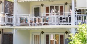 a white house with a white balcony at Heritage Lodge in Saint-François