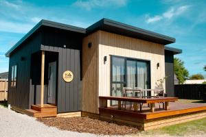a small house with a deck and a table at Taupo TOP 10 Holiday Park in Taupo