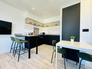 a kitchen with black and white counters and green stools at Central Bournemouth - 2-Bedroom - 4 Guests - Prime Spot in Bournemouth