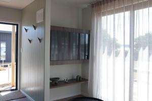 a living room with a window and a mirror at Taupo TOP 10 Holiday Park in Taupo +24 photos