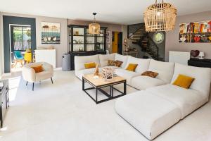 a living room with a white couch and a table at la maison du bassin Piscine & Spa Andernos in Andernos-les-Bains