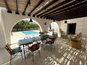 a patio with a table and chairs and a pool at Dar Néliah Djerba in Djerba