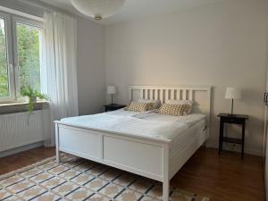 biała sypialnia z dużym białym łóżkiem z poduszkami w obiekcie Apartament w kamienicy Gdynia w mieście Gdynia