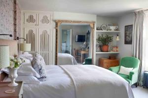 a bedroom with a white bed and a green chair at The George In Rye in Rye