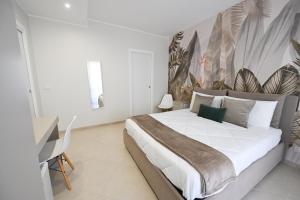 a white bedroom with a large bed and a desk at Barimare in Bari +37 photos