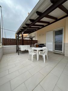 a patio with a table and chairs on a roof at Casa Francesca in Torre San Giovanni Ugento