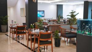 a restaurant with tables and chairs and a fish tank at Blue Moon Hotel in Erbil