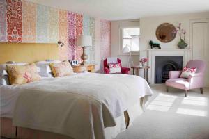 a bedroom with a bed and two chairs and a fireplace at The George In Rye in Rye