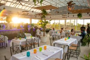 a restaurant with white tables and people sitting at them at Luxury 4-Bedroom Villa with Climate Pool in Sosúa +20 photos