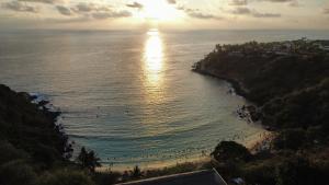 a view of a beach with the sun reflecting on the water at Hidden Port TTipis Vista Carrizalillo in Puerto Escondido +6 photos