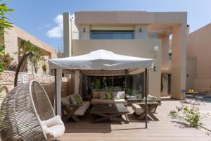 a patio with an umbrella and a couch and a table at Villa Golf Marrakech in Marrakech