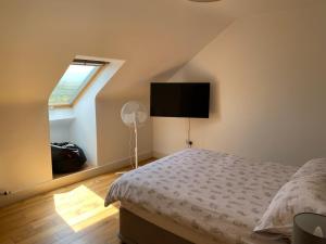a bedroom with a bed with a fan and a window at Beach House Inch in Inch