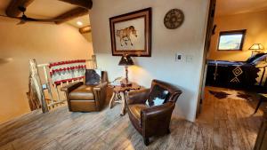 a living room with two chairs and a table and a bed at Sky Village in Cortez