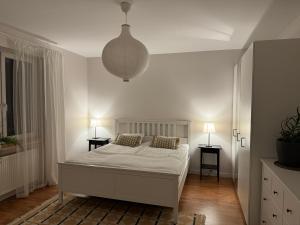 biała sypialnia z łóżkiem i 2 szafkami nocnymi w obiekcie Apartament w kamienicy Gdynia w mieście Gdynia
