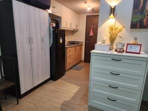 a kitchen with a white counter and a refrigerator at DG CONDOTEL @MANHATTAN PLAZA T2 STUDIO WITH BALCONY , 50 INCH TV AND UNLI WIFI @Araneta Cubao Quezon City Philippines in Manila