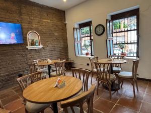 a restaurant with wooden tables and chairs and a tv at Hotel Terraza San Antonio in Cali