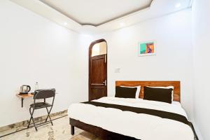 a bedroom with a bed and a desk and a chair at Hotel O Kiiza Stay House in New Delhi +21 photos